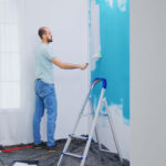 painting-apartment-wall-with-white-paint-using-roller-brush-handyman-renovating-apartment-redecoration-home-construction-while-renovating-improving-repair-decorating (1)